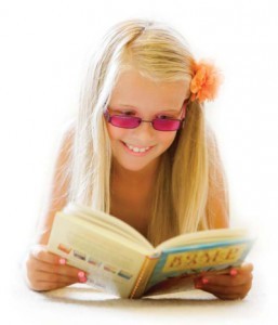 Young girl with tinted glasses reading a book